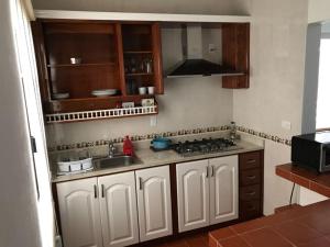 a kitchen with white cabinets and a sink and a stove at Casa Viveros in San Juan Teotihuacán