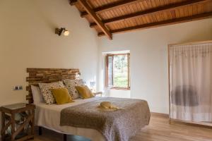 - une chambre avec un lit doté d'un chapeau dans l'établissement Casas del Molino - Muiños do Mainzoso Turismo Rural, à Paderne