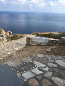 een stenen loopbrug met de oceaan op de achtergrond bij Villa Thori at Poulati Sifnos in Artemonas