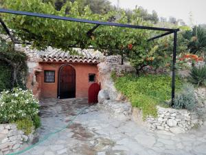un jardín con una casa con una manguera verde en Cueva El Parral, en Pegalajar
