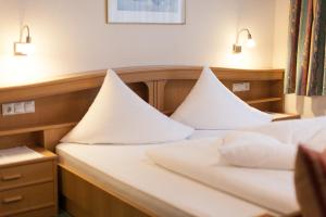 a bedroom with two beds with white pillows at Apart Alpenblick in Pfunds +15 photos