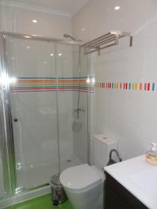 a bathroom with a toilet and a glass shower at Fisherman's Palace in Olhão +42 photos