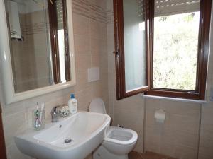 a bathroom with a sink and a toilet and a window at Casetta al Mare in Giustenice +27 photos