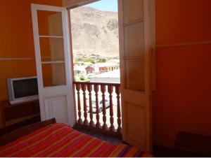 a bedroom with a view of a balcony with a television at Hospederia Taltal in Taltal
