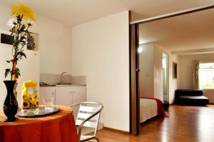 Una habitación con una mesa con un jarrón de flores encima. en ApartaHotel Los Alcazares, en Bogotá 54 fotos más