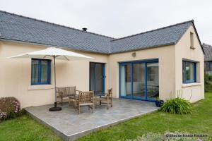 a patio with a table and chairs and an umbrella at La maison du port in Plougasnou