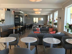 a restaurant with couches and tables and a bar at Strandhotellet in Öregrund