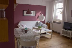 sala de estar con mesa y habitación con cama en Stadtflucht Lüneburg: Ferienwohnungen Innenstadt, en Lüneburg