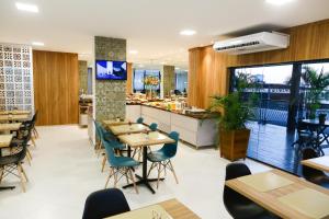 a restaurant with tables and chairs and a counter at Hotel Porto Madeira in Porto Velho