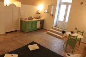 a kitchen with a green cabinet and a table at Casa Ela in Matera