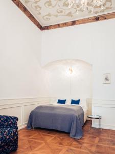a bedroom with a bed with blue sheets and a ceiling at Ofenloch Apartments in Vienna