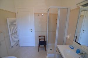 een badkamer met een stoel, een wastafel en een douche bij Levanto Rentals in Levanto