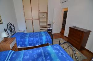 a bedroom with two beds and a dresser and a desk at Levanto Rentals in Levanto