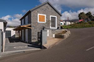 a stone house on the side of a street at Casa do Leme in Arco da Calheta +8 photos