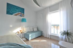 a bedroom with a blue couch and a window at Villa Katarina Mali Lošinj in Mali Lošinj