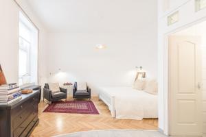 ブダペストにあるRose Trees Apartmentの白いベッドルーム(ベッド1台、椅子2脚付)