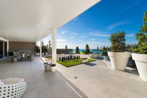 een patio met uitzicht op het water bij Belle Vue- Penthouse at Black Beach in Kiama