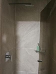 La salle de bains est pourvue d'une douche avec une porte en verre. dans l'établissement Miraflores Apart, à La Paz