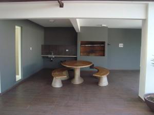 a kitchen with a wooden table and two benches at Hermoso Garzonier in Santa Cruz de la Sierra