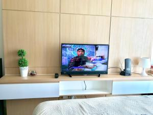 una TV a schermo piatto seduta sopra un tavolo di Apartment Tree Park BSD - 2101 a Serpong