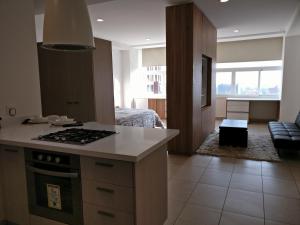 a kitchen with a stove top oven next to a living room at Boutique Apartment Carso Alameda-1102 in Mexico City