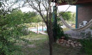 een hangmat in de tuin van een huis met een zwembad bij Postal Serrana in Villa Parque Siquiman +13 foto's