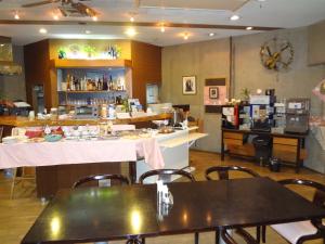 a restaurant with tables and a counter in a room at Asano Hotel in Kitakyushu