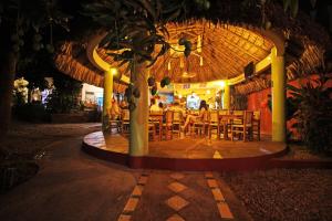 an outdoor dining area with tables, chairs and umbrellas at Casa Losodeli & Coworking- Adults Only in Puerto Escondido