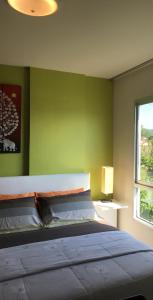 um quarto com uma cama com uma parede verde em D-condo mine em Kathu