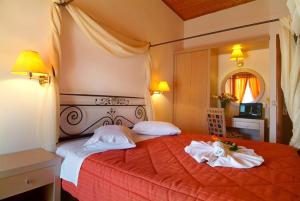 a bedroom with a red bed with two white pillows at Acropole Delphi City Hotel in Delphi