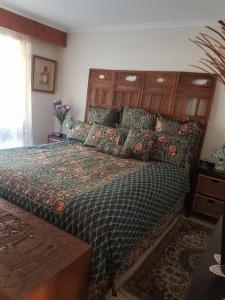 a bedroom with a large bed with a wooden headboard at Heavenly Farm B & B Tasmania in Boat Harbour