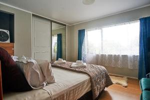 a bedroom with a bed and a large window at Applaud BnB in Drury