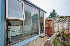 a house with large glass windows on a wooden deck at Applaud BnB in Drury