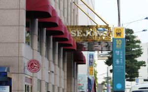 un bâtiment avec un panneau sur son côté dans l'établissement Sejong Hotel Seoul Myeongdong, à Séoul