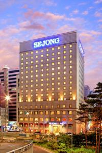 un bâtiment avec un signe solaire au-dessus de celui-ci dans l'établissement Sejong Hotel Seoul Myeongdong, à Séoul