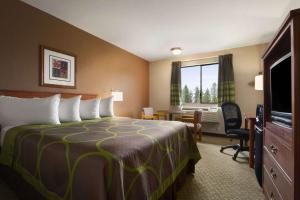 a bedroom with a bed, chair and a lamp at Super 8 by Wyndham Port Angeles at Olympic National Park in Port Angeles