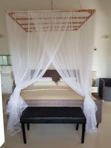 łóżko z moskitierą w pokoju w obiekcie Gästehaus Isabella w mieście Beruwala