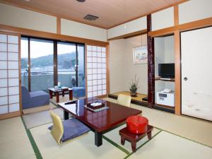 a japanese living room with a table and chairs at Daikanso in Chikushino