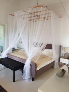 a bedroom with a canopy bed with mosquito nets at Gästehaus Isabella in Beruwala