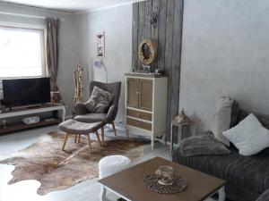 a living room with a couch and a table at Hüttenflair am See mit Kamin in Clausthal-Zellerfeld