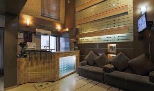 a living room with a couch and a bar at Hotel Apple Inn Vapi in Vapi