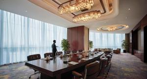 a man standing in a conference room with a long table at Shangri-La Yiwu in Yiwu