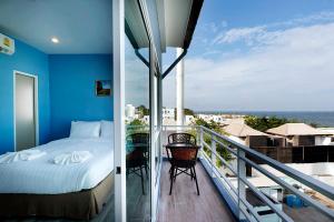 a balcony with a bed and a view of the ocean at Nantra Hua Hin in Hua Hin