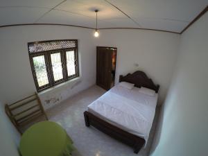 una camera da letto con un letto, una sedia e una finestra di Bimanjee Mango Resort a Matara