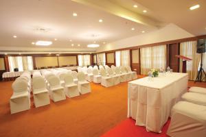 a banquet hall with white tables and white chairs at Broad Bean Cochin in Cochin