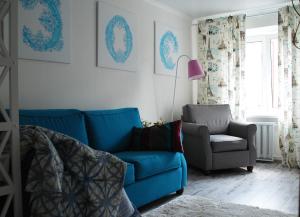 sala de estar con sofá azul y silla en Бело-голубая безмятежность en Chernihiv