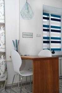 a desk with two white chairs in a room at Бело-голубая безмятежность in Chernihiv