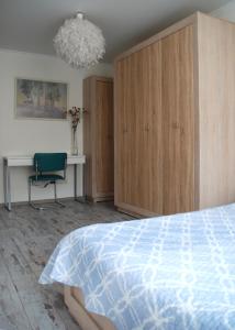 ein Schlafzimmer mit einem Bett, einem Stuhl und einem Kronleuchter in der Unterkunft Бело-голубая безмятежность in Tschernihiw