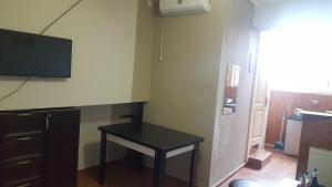 a room with a table and a tv on the wall at Vazi in Tbilisi City