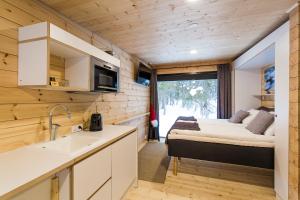 a kitchen and living room in a tiny house at Vaattunki Wilderness Resort in Rovaniemi